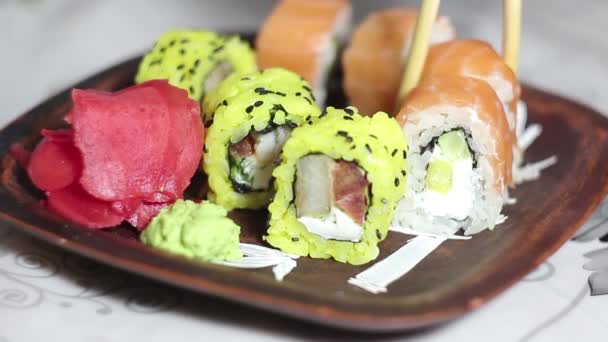 Chef coloca los rollos de sushi en un plato antes de servirlos a los clientes . — Vídeo de stock