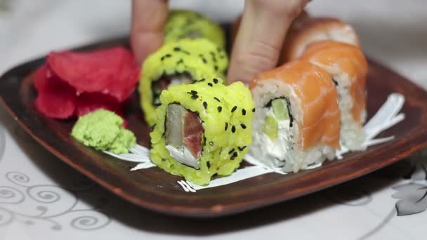 Ręka zabiera roll sushi z płyty. — Wideo stockowe