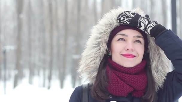 Menina bonita exala ar frio, sorri e bebe café de uma xícara em um parque de inverno . — Vídeo de Stock