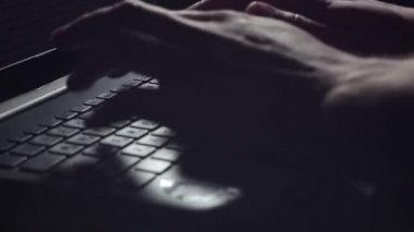 Genç adam onun dizüstü bilgisayarda çalışır, yazdırır ve touchpad kullanır.