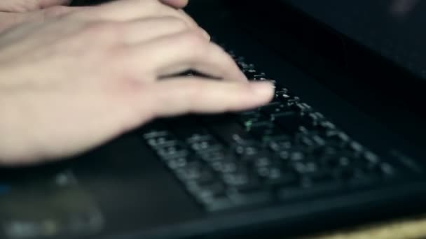 Νεαρός άνδρας λειτουργεί σε φορητό υπολογιστή του, να εκτυπώνει και να χρησιμοποιεί το touchpad. — Αρχείο Βίντεο