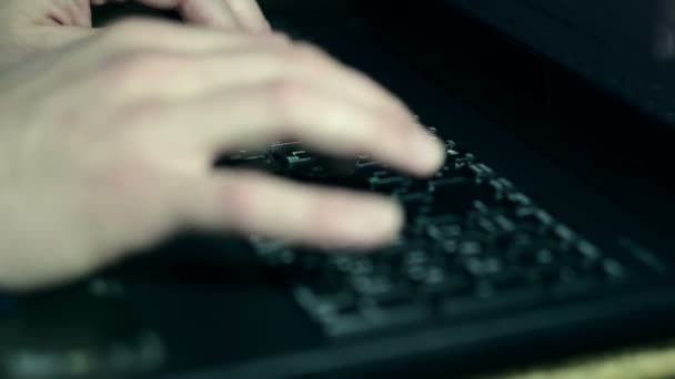 Young man works on his laptop, prints and uses the touchpad. — Stock Video