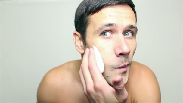 Ung snygg kille gäller raklödder på att raka. — Stockvideo