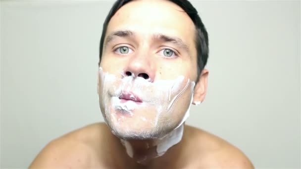 Genç yakışıklı adam yüzünü bir ustura ile tıraş.. — Stok video