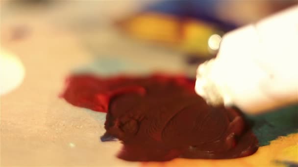 Artist squeezes white paint from the tube onto the palette. — Stock Video