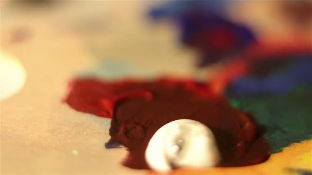 Artist mixes on the palette white and red paint. — Stock Video