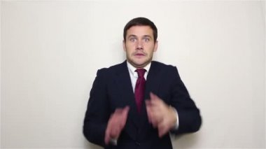 Genç yakışıklı iş adamı korku tehlike silkiyor ve elleriyle yüzünü kapsar.