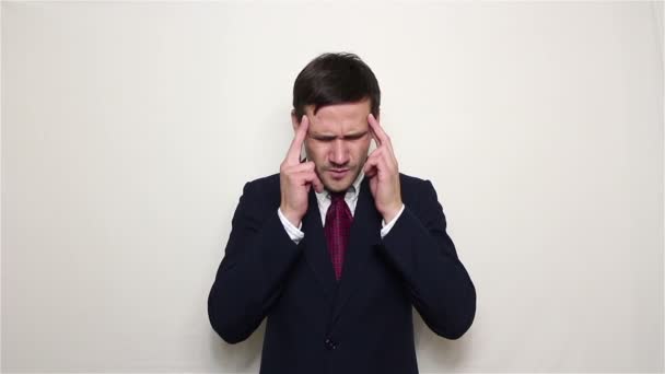 Młody przystojny biznesmen w Niebieski garnitur cierpi na ból głowy. — Wideo stockowe
