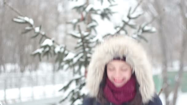 Vacker ung flicka kastar upp snön med händerna och aktivt uttryckte glädje, skratt och klappar händerna. — Stockvideo