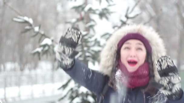 Όμορφη νεαρή κοπέλα ενεργά εξέφρασαν τη χαρά, να γελάει και να χαίρεται με το χιόνι που υπάγονται. — Αρχείο Βίντεο