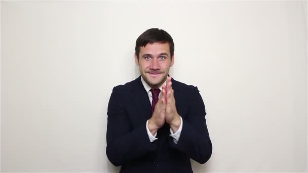 Joven hombre de negocios guapo está sonriendo y frotando sus manos. — Vídeos de Stock