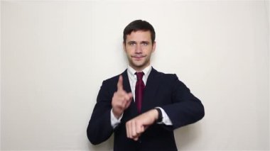 Genç yakışıklı işadamı saatine işaret ve hoşnutsuzluğunu başını sallayarak.