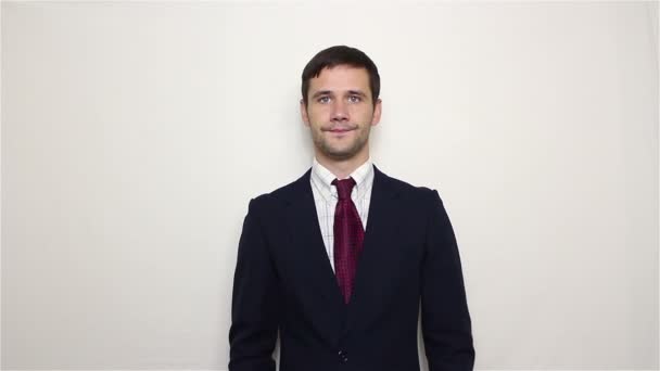 Young handsome businessman with a serious face points his finger at the clock. — Stock Video