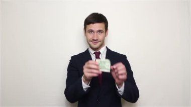 Genç yakışıklı işadamı bir dolar cebinden çeker ve gösterir.