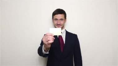 Altın kredi kartını kameraya dışarı genç yakışıklı işadamı tutar.