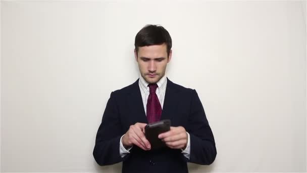 Jovem empresário bonito puxa um cartão de crédito dourado de sua carteira . — Vídeo de Stock
