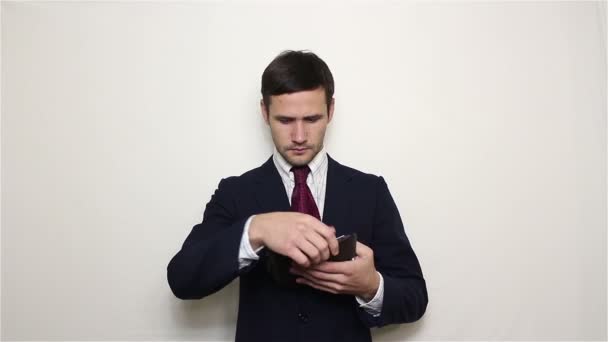 Joven hombre de negocios guapo buscando dinero en su cartera . — Vídeos de Stock
