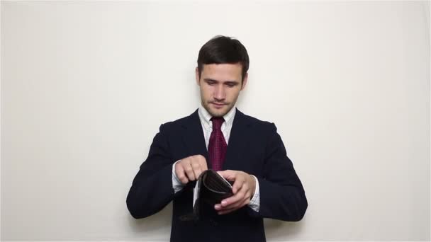 Jovem empresário bonito está à procura de dinheiro em sua carteira e encontra um dólar . — Vídeo de Stock