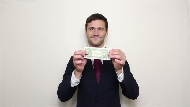 Jovem homem de negócios bonito espremer um dólar em suas mãos e joga-lo nas costas . — Vídeo de Stock