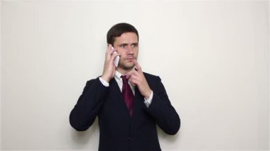 Genç yakışıklı işadamı onun smartphone üzerinde bir müşteri ile konuşurken.