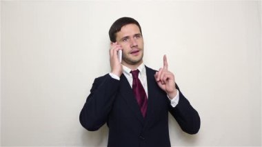 Genç yakışıklı işadamı telefonda konuşuyor..