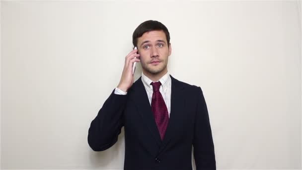 Młody przystojny biznesmen jest szeroko uśmiechający się podczas rozmowy telefonicznej z klientem. — Wideo stockowe