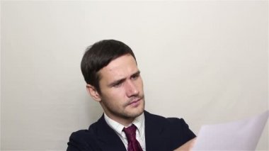 Genç yakışıklı işadamı geniş gülümsüyor ve onaylayarak kafasını sallıyor.