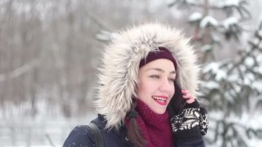 Güzel genç kız kış parkta yürürken onu Smartphone'da konuşuyor.