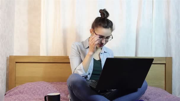 一个年轻美丽的女孩从笔记本电脑上摘下眼镜. — 图库视频影像