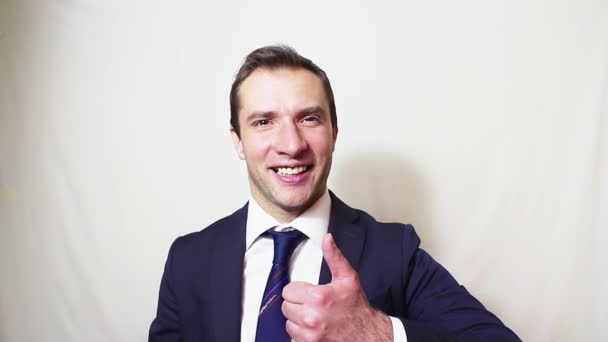 Jovem empresário bonito sorrindo e mostrando o polegar para cima  . — Vídeo de Stock