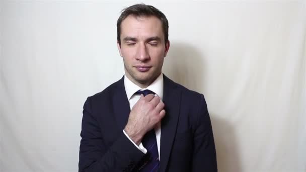 Young handsome businessman cleans and adjusts his suit, smiling looking at camera — Stock Video