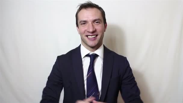 Joven hombre de negocios guapo sonriendo y aplaudiendo activamente, saludando a nuevos clientes — Vídeo de stock
