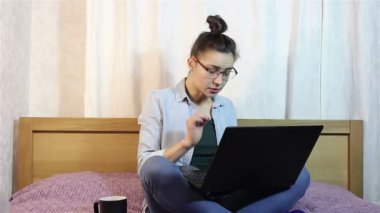 Genç, güzel bir kız onu laptop çalışma yorgunluğu gözlerinden sürtünme.