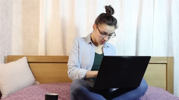 一个年轻美丽的女孩揉她的眼睛从疲劳工作在她的笔记本电脑上. — 图库视频影像