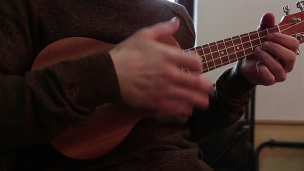 Manos de un joven tocando el ukelele . — Vídeo de stock