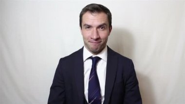 Genç yakışıklı işadamı gülümsüyor ve ellerini ovuyor..