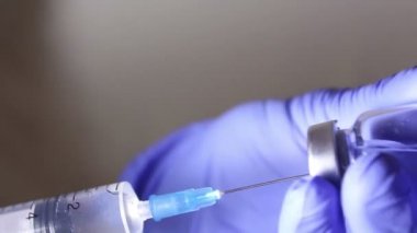 Doktorlar eller çözüm hasta enjeksiyon için hazırlama ilaç karıştırma bir şırınga ile aşı bir şişe enjekte.