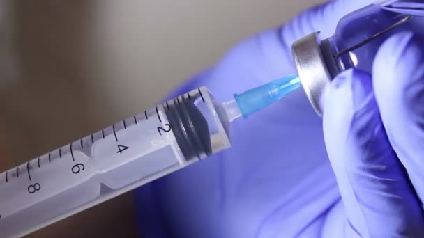 Врачи вручную наполняют шприц вакциной, готовясь к инъекции пациенту. — стоковое видео