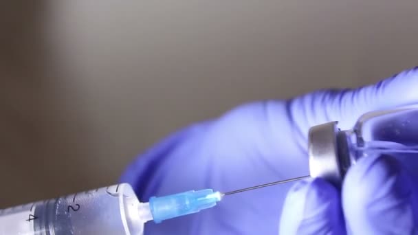 Лікарі руки вводять розчин у флакон вакцини шприцом, змішуючи ліки, готуючись до ін'єкції пацієнта . — стокове відео