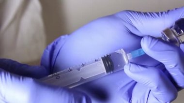 Doktorlar eller çözüm hasta enjeksiyon için hazırlama ilaç karıştırma bir şırınga ile aşı bir şişe enjekte.