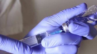 Doktorlar şırıngayı aşıyla doldurup hastaya iğne yapmaya hazırlanıyorlar..