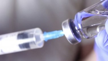 Doktorlar şırıngayı aşıyla doldurup hastaya iğne yapmaya hazırlanıyorlar..