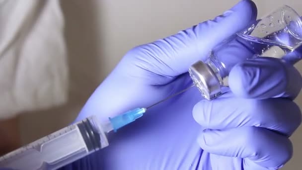 As mãos dos médicos enchem a seringa com a vacina, preparando-se para a injeção no paciente.. — Vídeo de Stock