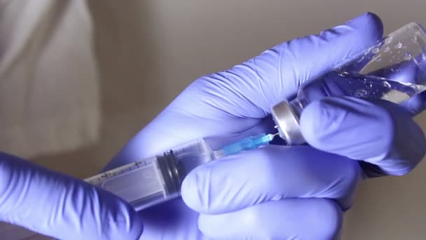 Врачи вручную наполняют шприц вакциной, готовясь к инъекции пациенту. — стоковое видео