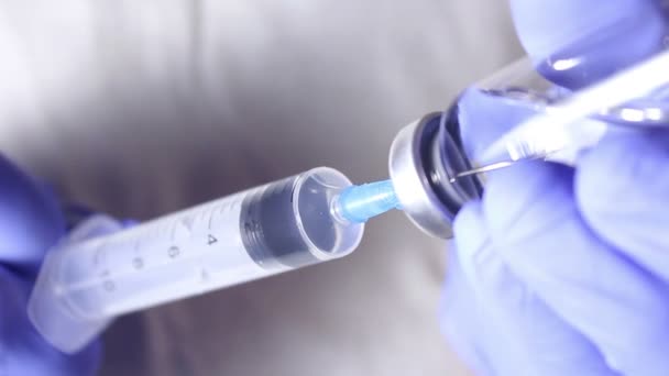 Doctors hands fill the syringe with vaccine, preparing for the injection of the injection to the patient. — Stock Video