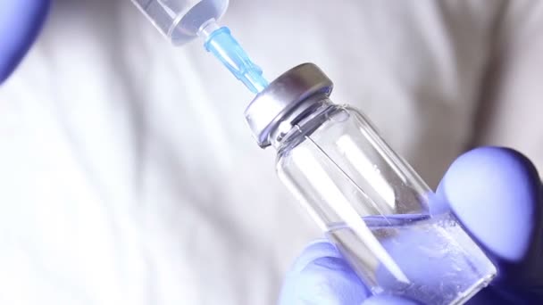 Doctors hands inject the solution into a vial of vaccine with a syringe, mixing the medication, preparing for the injection of the patient. — Stock Video