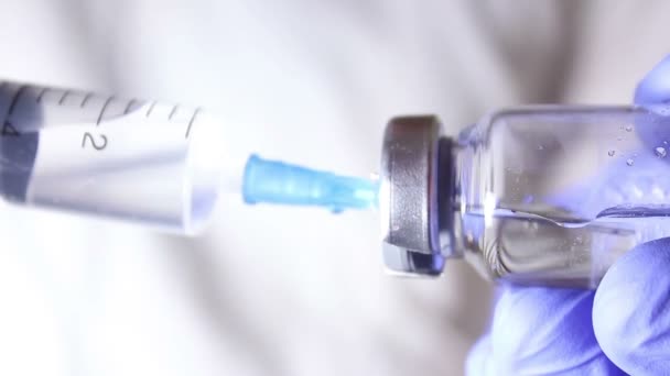 Лікарі руки заповнюють шприц вакциною, готуючись до ін'єкції пацієнта . — стокове відео