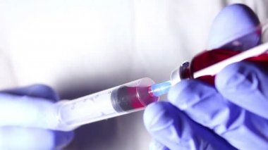 Doktorlar eller bir enjeksiyon hasta hazırlama kırmızı bir aşı ile şırıngaya doldur.