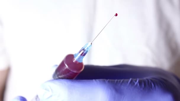 As mãos dos médicos libertam o excesso de sangue da seringa . — Vídeo de Stock