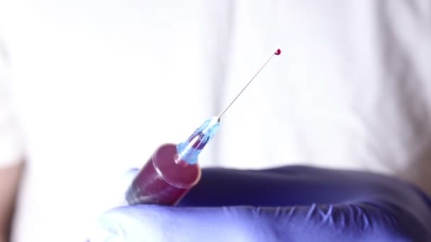 Ärzte Hände geben überschüssiges Blut aus der Spritze ab. — Stockvideo